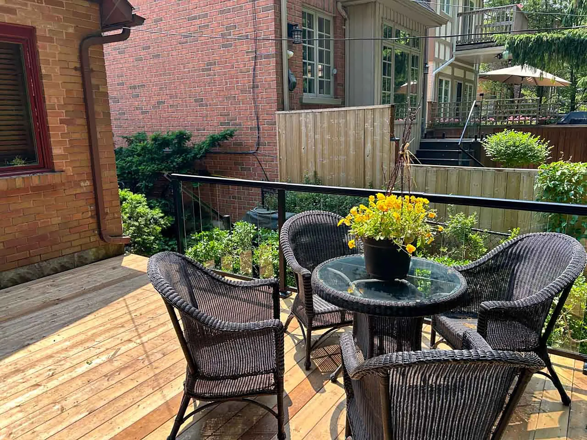 Custom wood deck with glass railing in a Toronto backyard